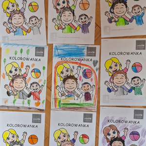 Dinusie" kolorują kolorowankę UNICEF-u.
